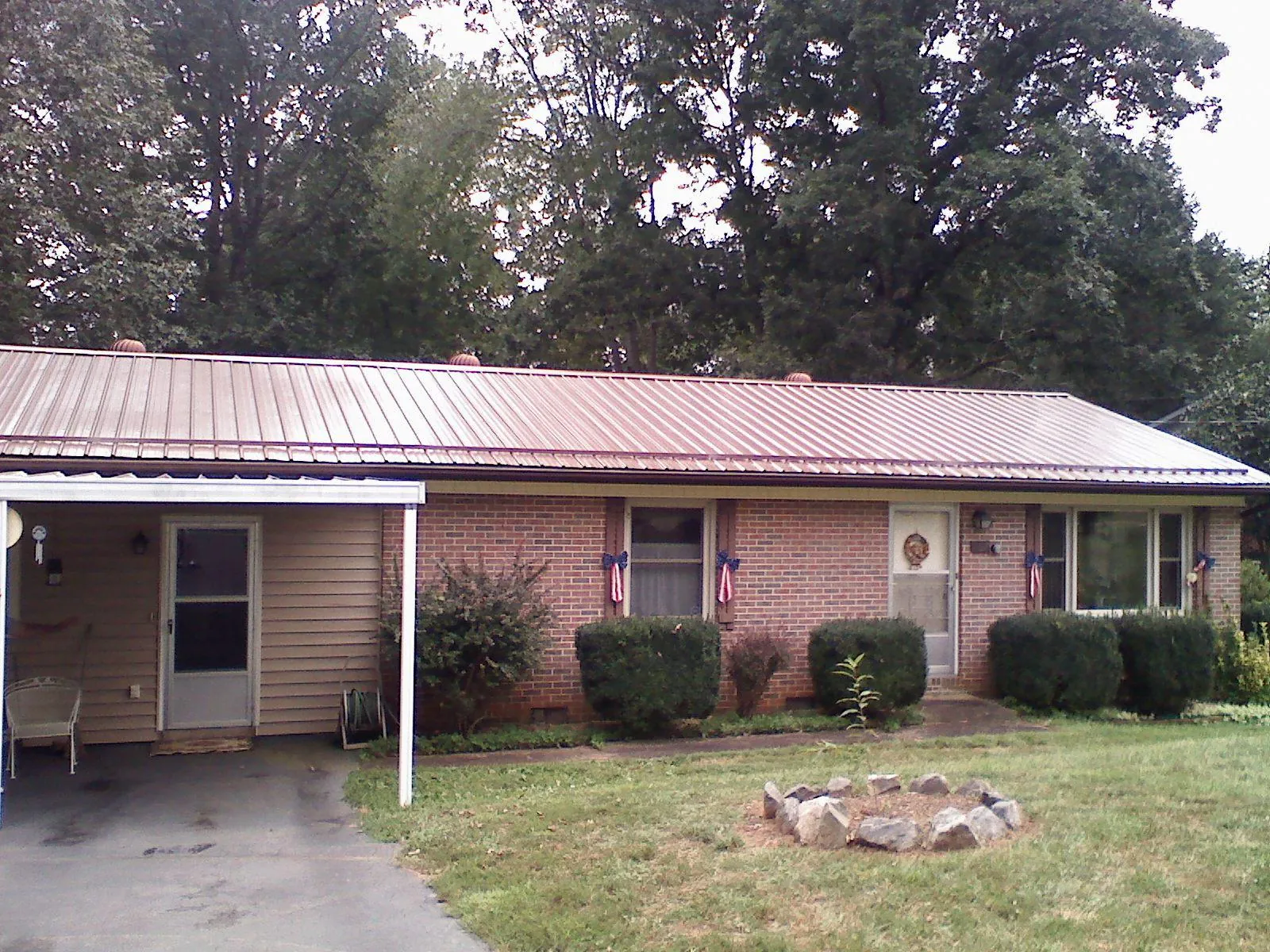 Bronze metal roof and carport on a brick ranch home — Roof Repair work by our crew in Ridge